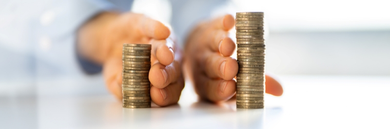 Dłonie dzielące monety na dwa oddzielne stosy, symbolizujące ustanowienie rozdzielności majątkowej małżonków